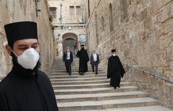Worshippers and Orthodox Christian clergymen wear masks on Orthodox Good Friday