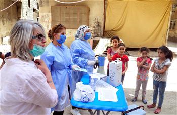 Medical workers give vaccines to children in Damascus
