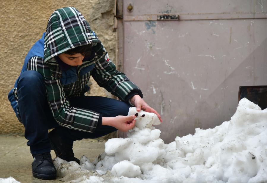 Children play snow in Damascus, Syria