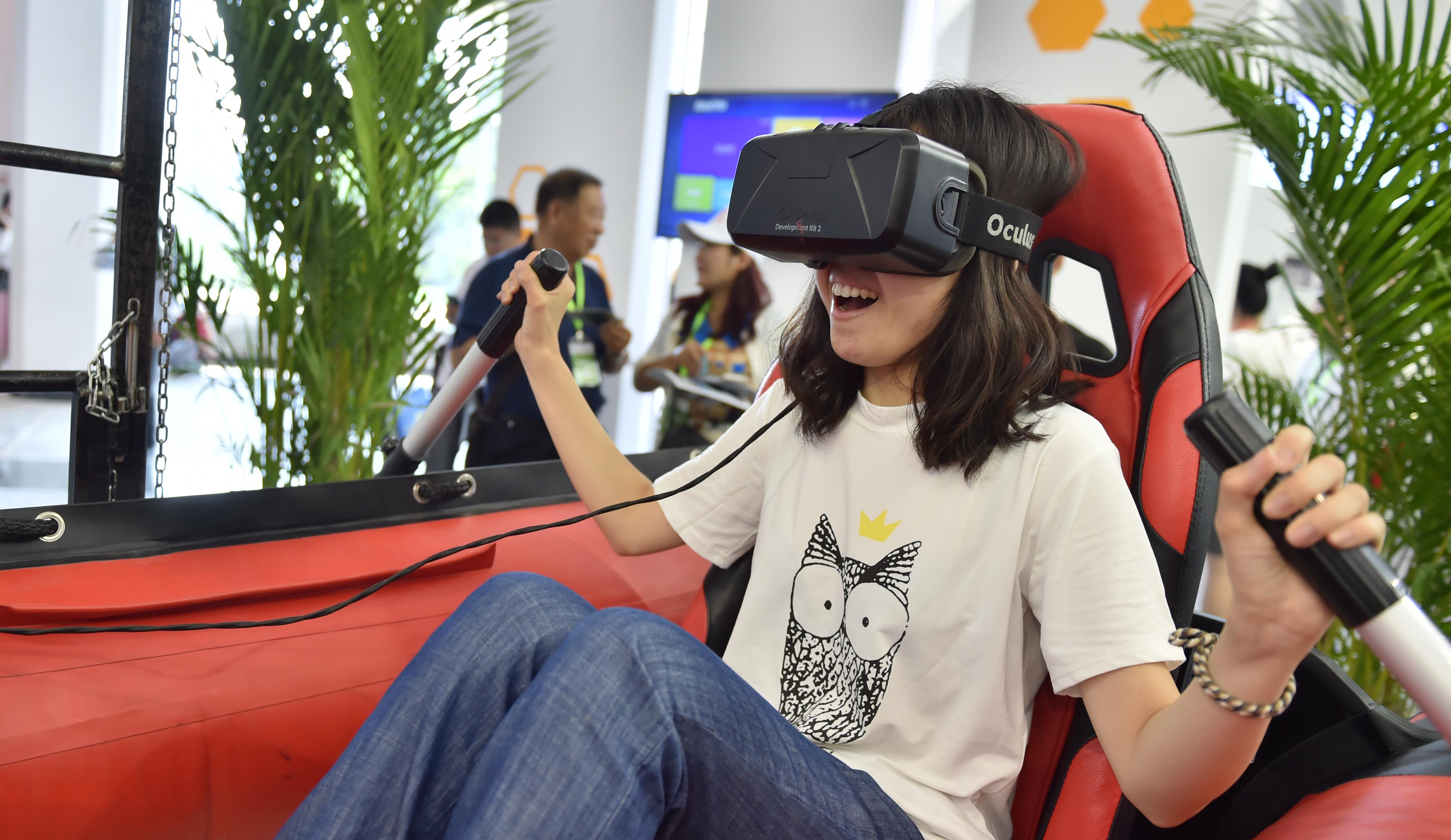 参观者在&ldquo;皮筏艇&rdquo;上体验VR技术模拟的水上场景