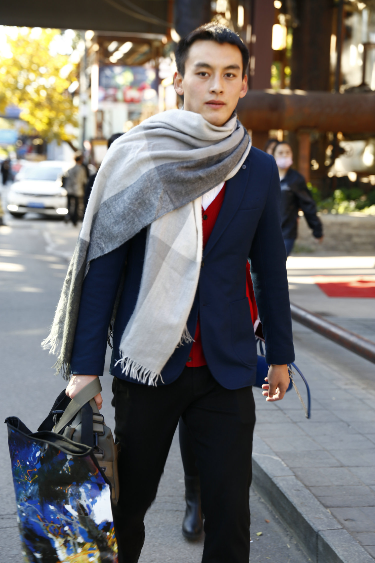标志性的大格纹围巾巧妙了打破了西装的沉闷感，露出有些闷骚的红色马甲背心。