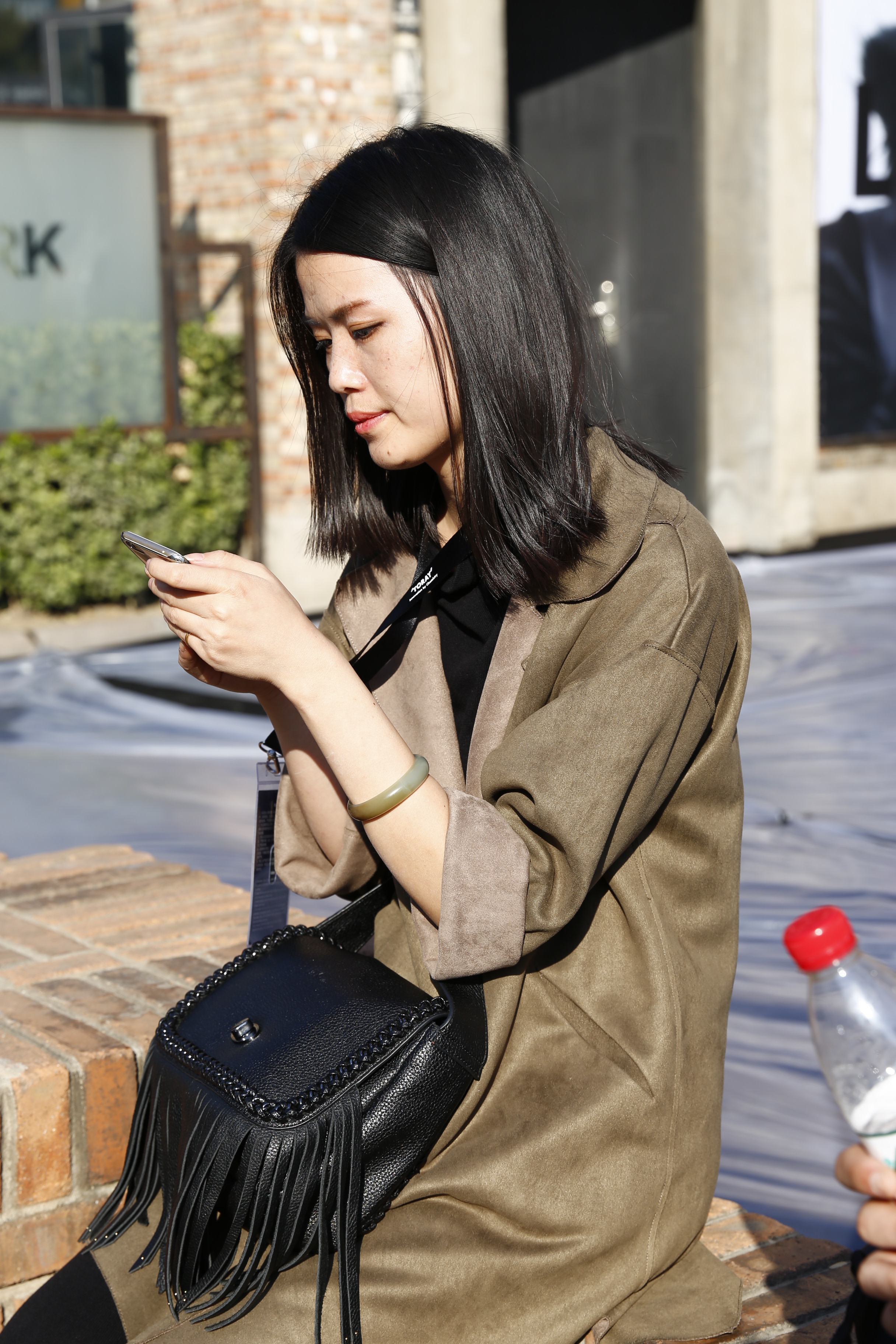 时装周艳丽的背后，是每一位工作人员的汗水。图为秀场工作人员正在协调看秀事宜。