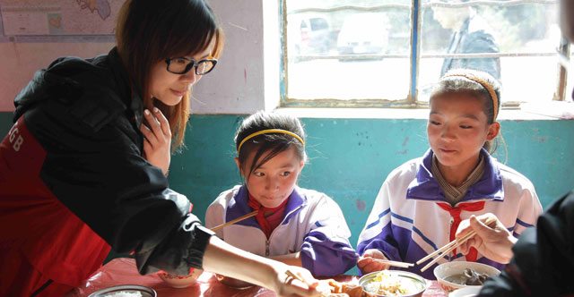 2011年10月，广发志愿者们亲赴宁夏回族自治区同心县和海原县。图为志愿者和孩子吃饭。