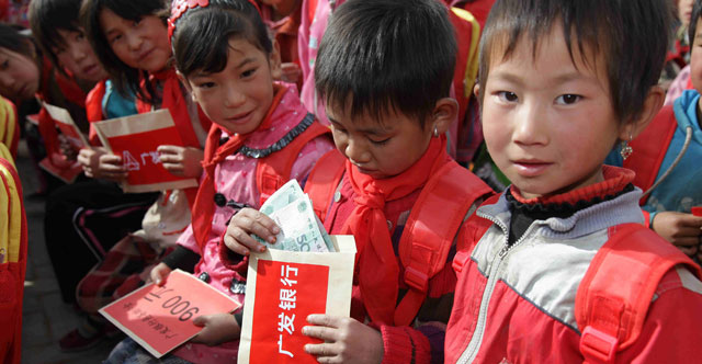 2011年10月，广发志愿者亲赴宁夏回族自治区同心县和海原县。图为贫困儿童领到助学金。