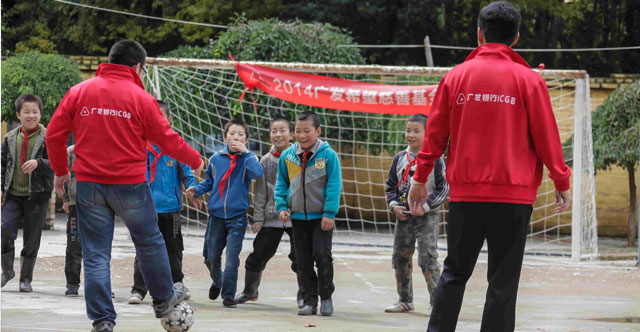 2014年9月，广发志愿者们前往甘肃省陇西县和平凉市。图为志愿者与孩子踢足球。