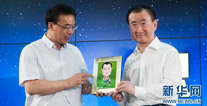 新华网足球队负责人孙巍向王健林赠送漫画