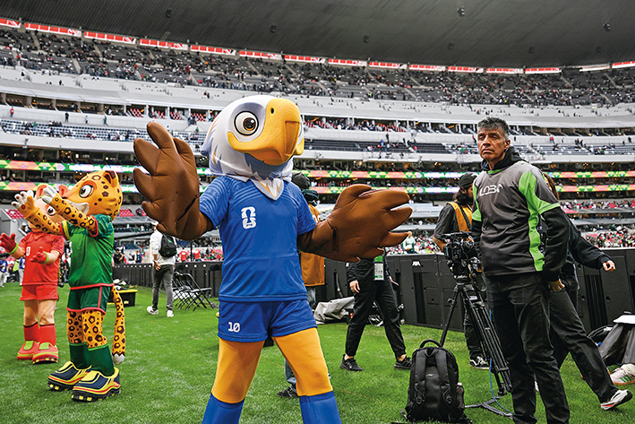 2026年3月28日，在墨西哥首都墨西哥城举行的一场国际足球友谊赛赛前，2026 美加墨世界杯吉祥物活跃气氛 李木子摄/本刊