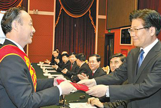 2013年12月6日，张春贤为张飚颁发奖章、证书。