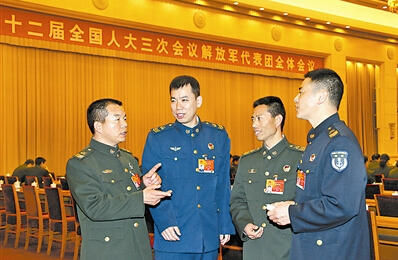 资料图：解放军代表团第二次全体会议休息间隙，4位高级士官代表巨孝成、杜洪强、王忠心、黄良平（从左至右）进行交流。