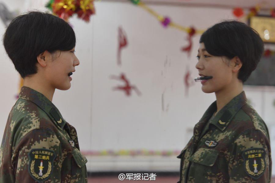 我军秀丽话务女兵咬笔练微笑