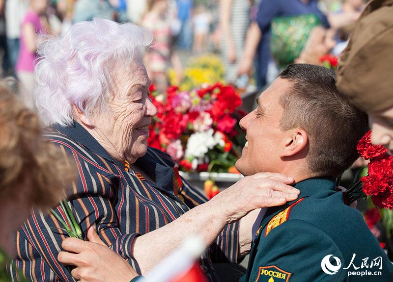 一名士兵送上鲜花后激动地拥抱老兵（人民网记者 屈海齐 摄）