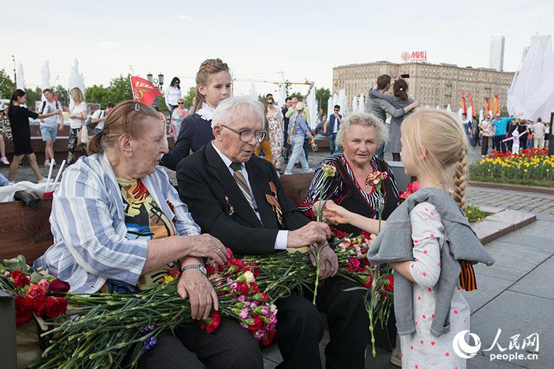 向老兵们献花的儿童（人民网记者 屈海齐 摄）