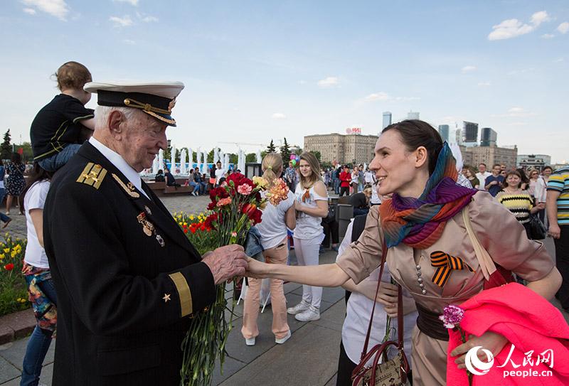 女孩向老兵送上鲜花（人民网记者 屈海齐 摄）