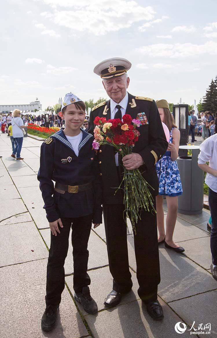 一名少年与老兵合影（人民网记者 屈海齐 摄）