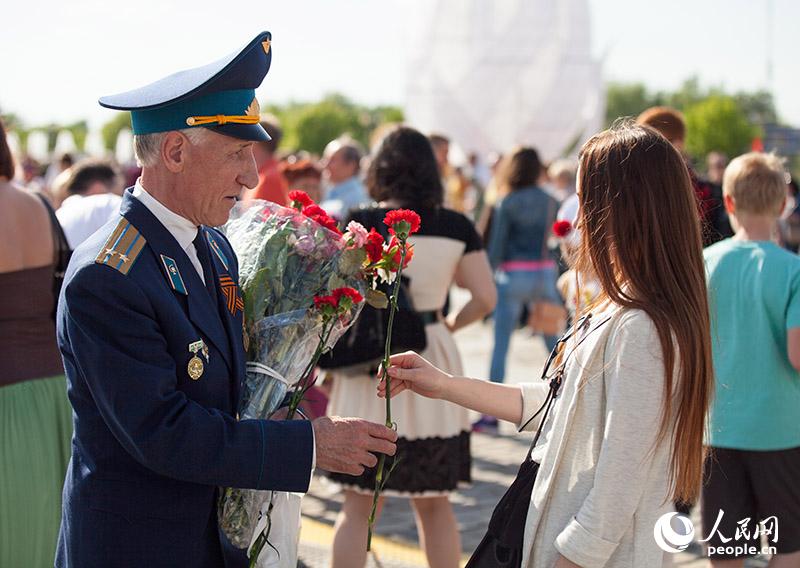 女孩向老兵送上鲜花（人民网记者 屈海齐 摄）