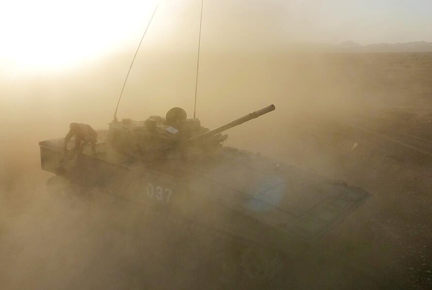 &uarr;国产某新型步战车高速急停后，官兵在尘土飞扬中进行弹药快速补给。新华社记者琚振华摄 