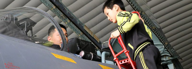 小朋友探身好奇观看歼11座舱