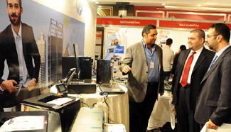 Visitors watch computer accessories at tech fair in Damascus, Syria