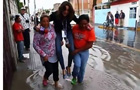 墨西哥女记者报道洪水怕湿鞋被抬着走