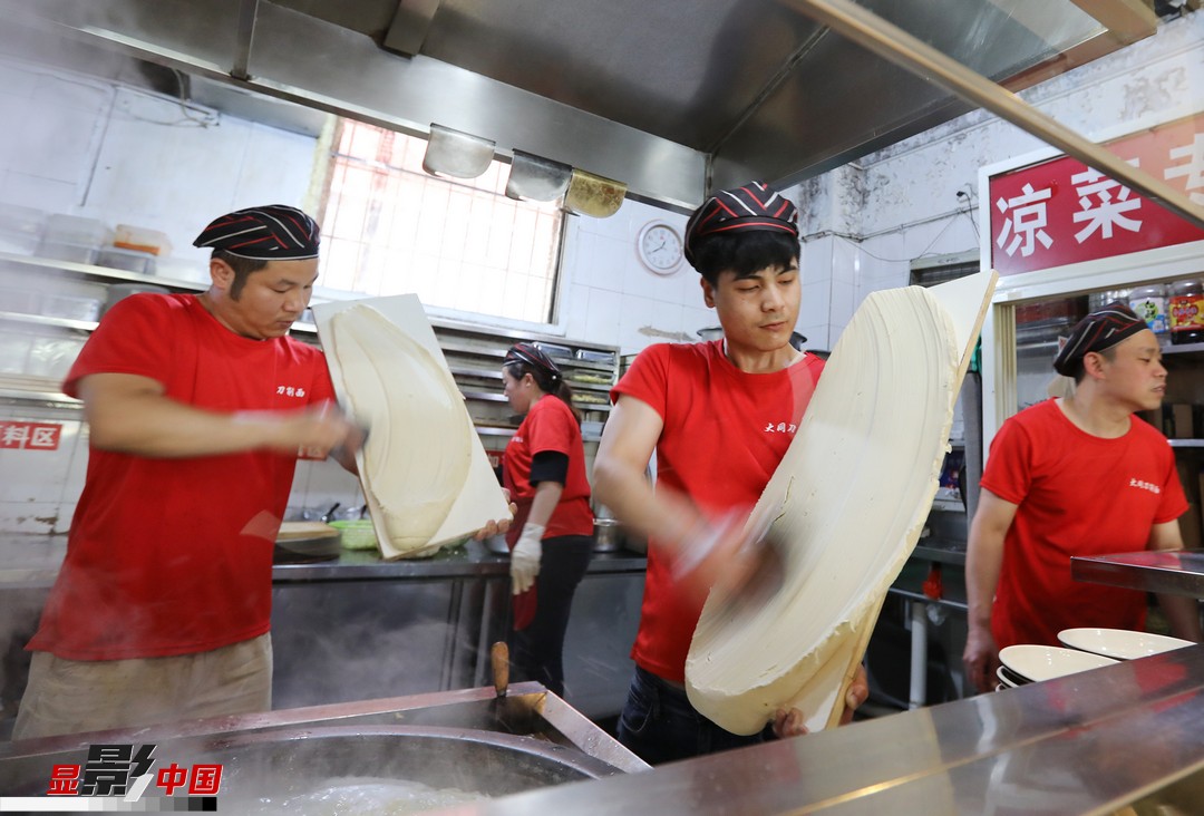 图为2019年5月16日,开封市大王屯东街大同刀削面馆,厨师们在制作刀