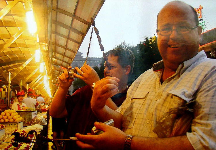 旅游接待能力、服务水平大幅提升。图为外国游客在北京东华门夜市品尝中国传统小吃。