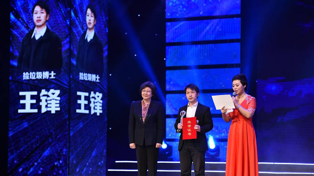 中央网信办副主任王秀军为“捡垃圾博士”王锋颁奖