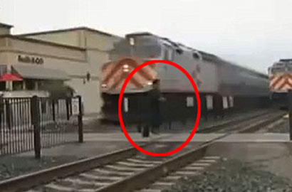 美男子橫穿鐵軌與列車擦身而過