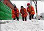 12月14日，天津城区普降中到大雪，十八大代表、天津市河北区环卫工人徐文华（中）与工友们一起加紧清扫道路积雪。新华社记者 张超群 摄