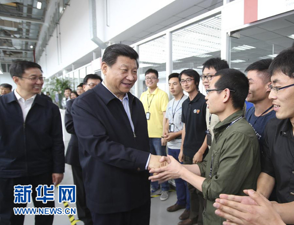 这是24日上午，习近平在上海汽车集团技术中心造型设计车间考察时与员工亲切握手。新华社记者兰红光摄 