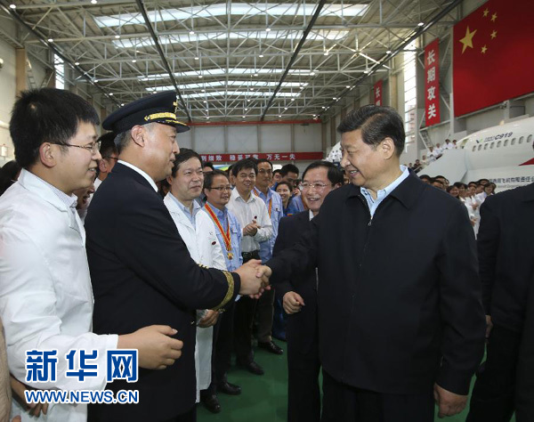 这是23日下午，习近平在中国商飞设计研发中心综合试验大厅与试飞工程师、科研人员亲切握手。新华社记者兰红光摄 
