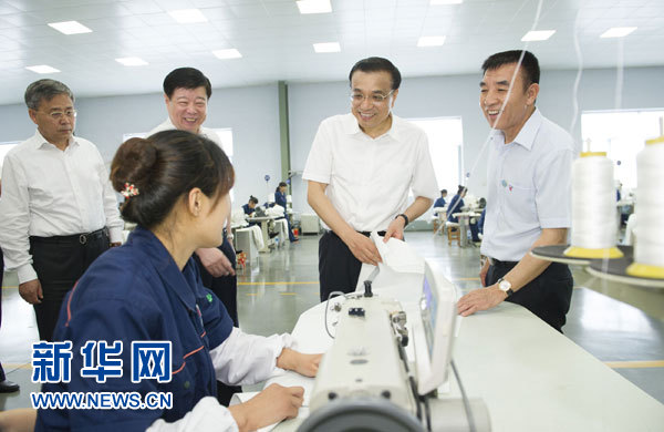 7月24日至25日，中共中央政治局常委、国务院总理李克强在山东考察。这是7月24日，李克强在德州景津公司考察时与工人交谈。新华社记者黄敬文摄