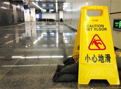 昨日中午，地铁14号线东湖渠站，漏水处摆放着沙袋及警示牌。因上方污水管被挖断，积水渗入地铁站。实习生