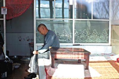 2014年12月19日,赵志红父亲坐在炕边休息。每次提到赵志红,他都会不断地叹气。新京报记者 周岗峰 郭铁流 摄