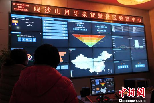 甘肃敦煌鸣沙山月牙泉景区。图为游客骑骆驼游玩。 刘玉桃 摄