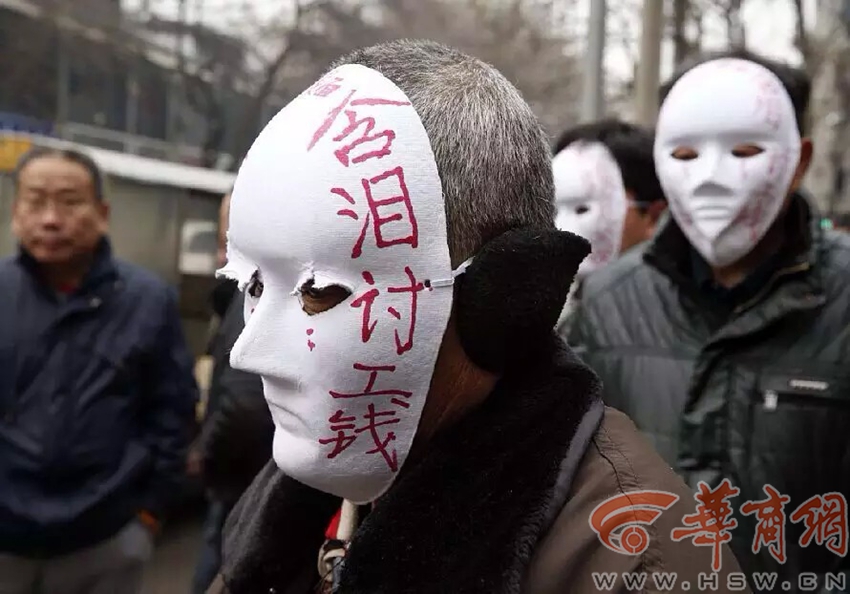 包工头拖欠工资后失联 民工带面具街头讨薪