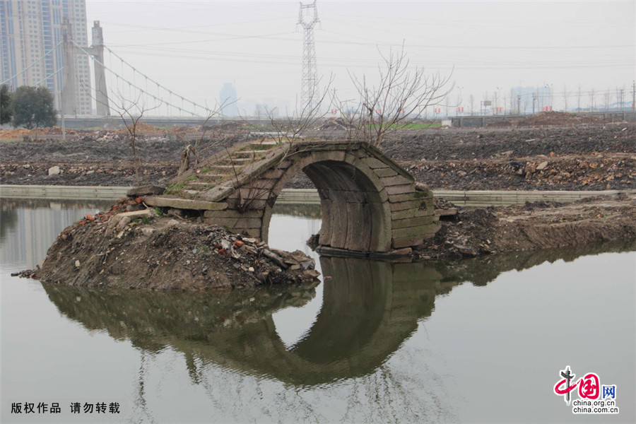 2015年3月3日下午，浙江绍兴市区镜湖湿地公园一条等待拓宽的河道中，一座已经有三四百年历史、建于清代的单孔石拱桥正孤零零地矗立在河道中。中国网图片库 李瑞昌/摄