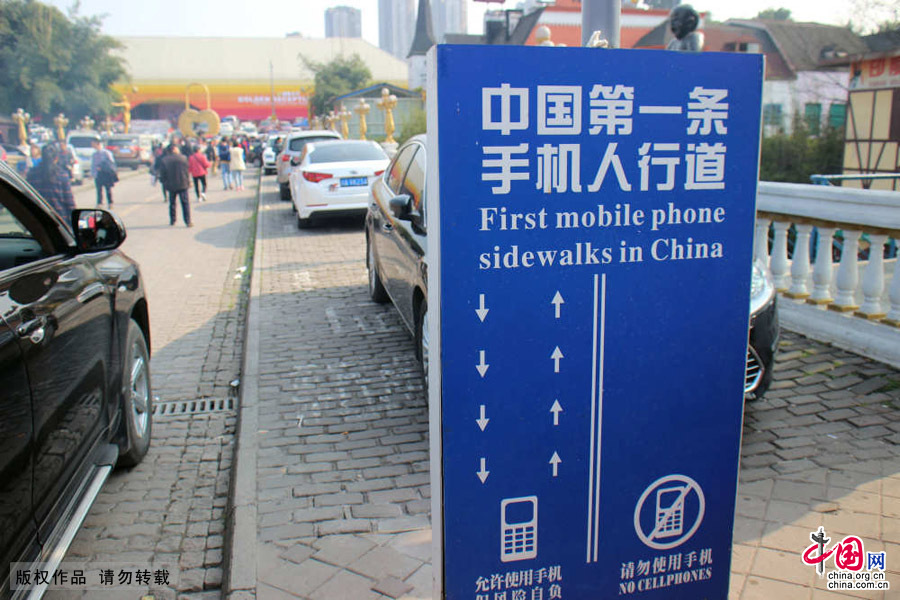 2015年3月8日，重庆，一度被网络热议的中国第一条“手机人行道”上停满了汽车，变成了“停车场”，形同虚设。中国网图片库 刘向龙/摄