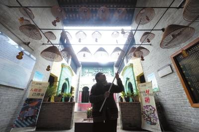 87岁的梁洁源每天代姐妹们点燃盘香。