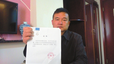 朱洪华向记者展示相关部门为其出具的家庭困难证明。京华时报记者张淑玲摄