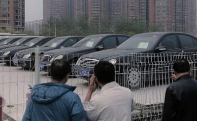 昨天，待拍公车停在场地内，市民隔着围栏张望。