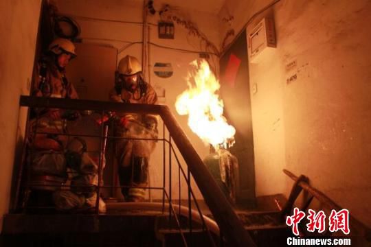 浙江消防现“抱火哥”双手拎出喷火煤气罐(图)