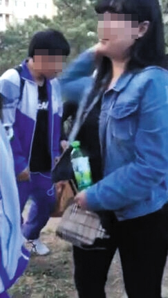 牛仔衣女孩伸手欲打人。