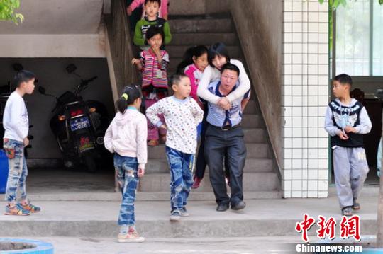 吴富蓉被丈夫背着出教室。 吴平华 摄