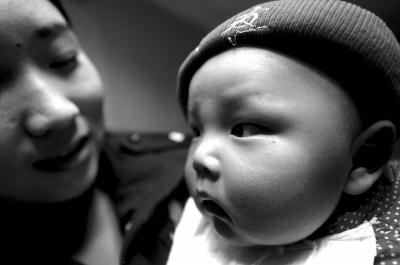 明明被警方成功解救，孩子在女民警的怀里一直没有哭闹。京华时报记者欧阳晓菲摄