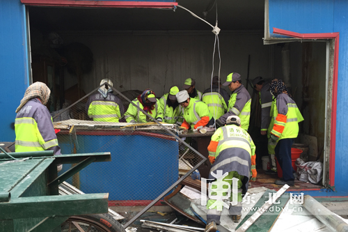 环卫工整理被破坏的休息间。