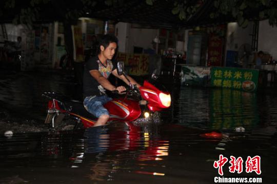 图为柳州市柳江县拉堡镇积水路段,一辆摩托车在水中穿行。 朱柳融 摄