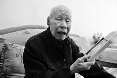 老兵范润拿出当年当兵入伍时的照片追忆往昔。