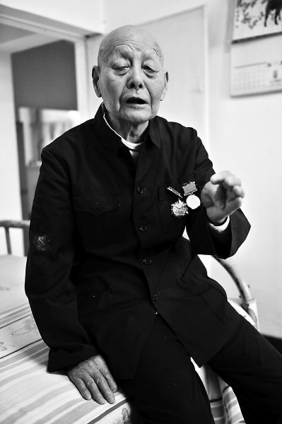 今年87岁的老兵闫忠，抗战时与鬼子搏斗左臂受伤，至今都不能正常弯曲。