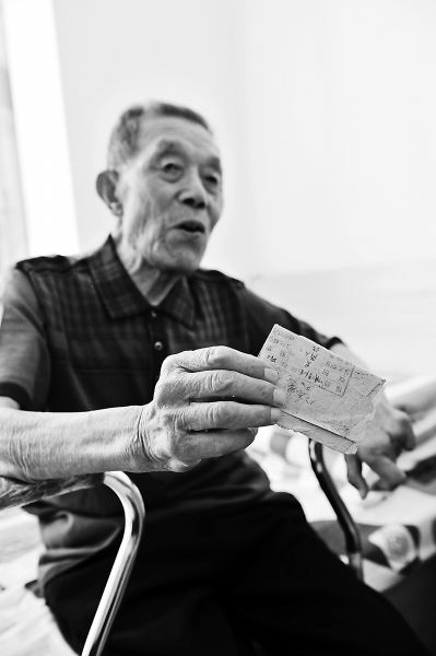 刘景旺翻出当年的入党志愿书，与敌人搏斗的血渍至今还在。