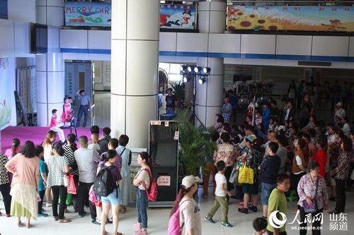 5月24日，济南市青少年宫一楼大厅，家长们或站着或坐着，观看孩子们的演出。高彪 摄